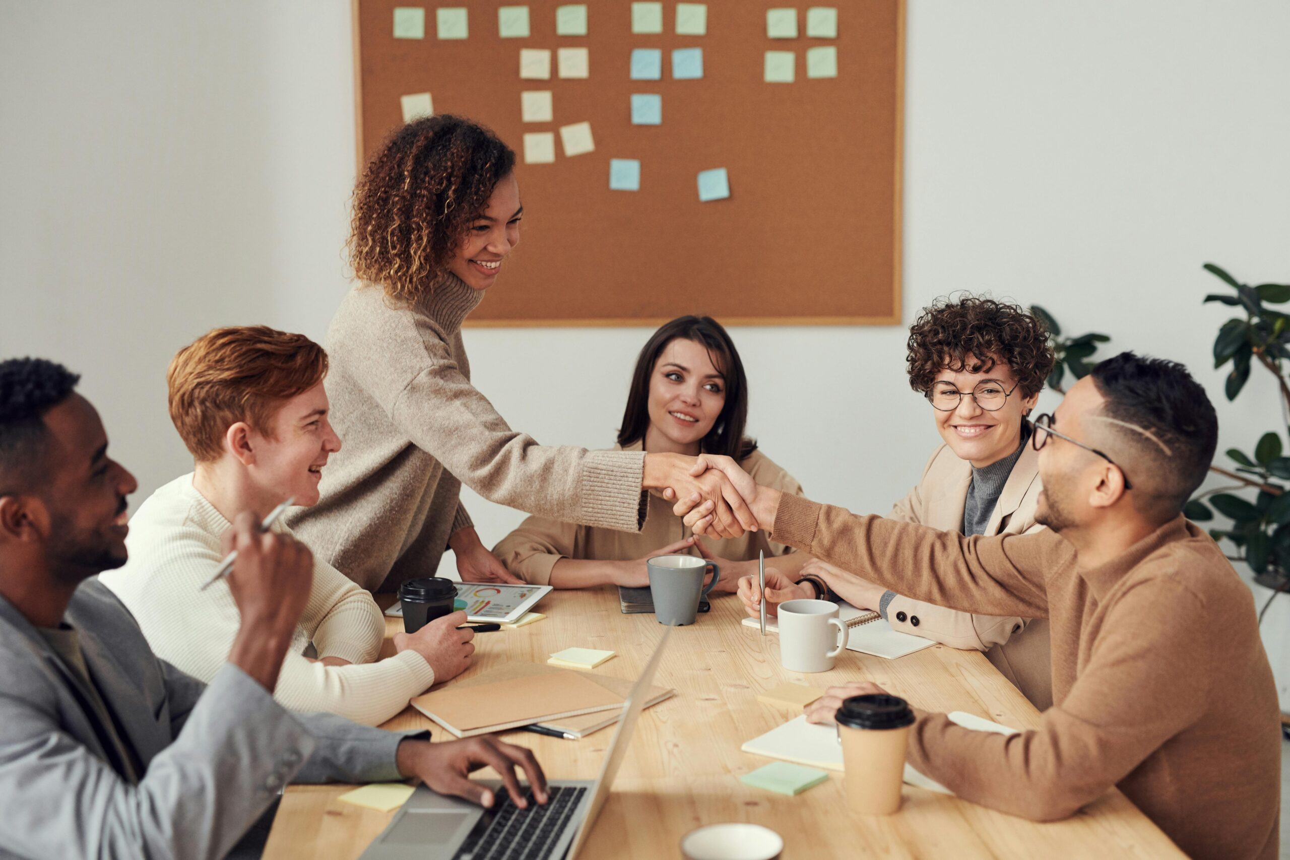 Two colleagues shaking hands in a marketing consulting firm.